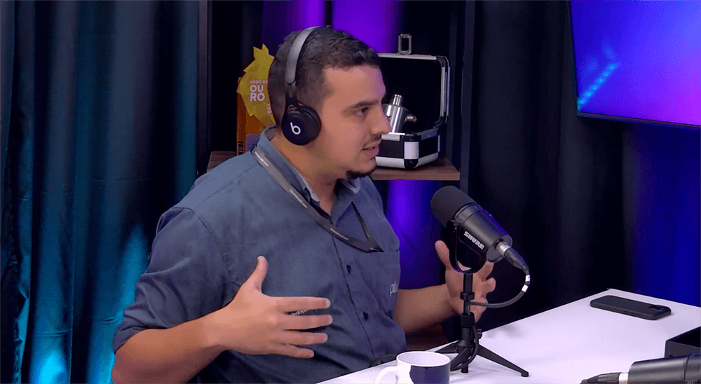 Danilo, participante de podcast, falando ao microfone durante gravação em estúdio.