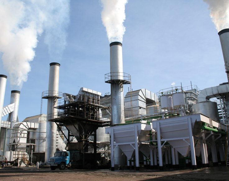 Estrutura industrial de uma usina de açúcar e álcool com dutos, chaminés e equipamentos do processo produtivo.