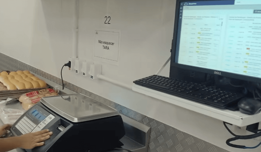 Balança de bancada da Toledo do Brasil integrada ao MGV Cloud, mostrando operação de pesagem e emissão de etiquetas no varejo.
